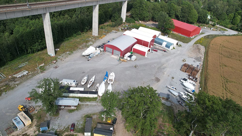 Drönarbild över fullservicevarvet Wasa Yachts nära Stockholm. På bilden syns hallar för inomhusförvaring av båtar samt uppställningsyta utomhus.